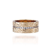 The picture shows a 14K yellow gold wave diamond channel 8 mm ring with hand-engravings.