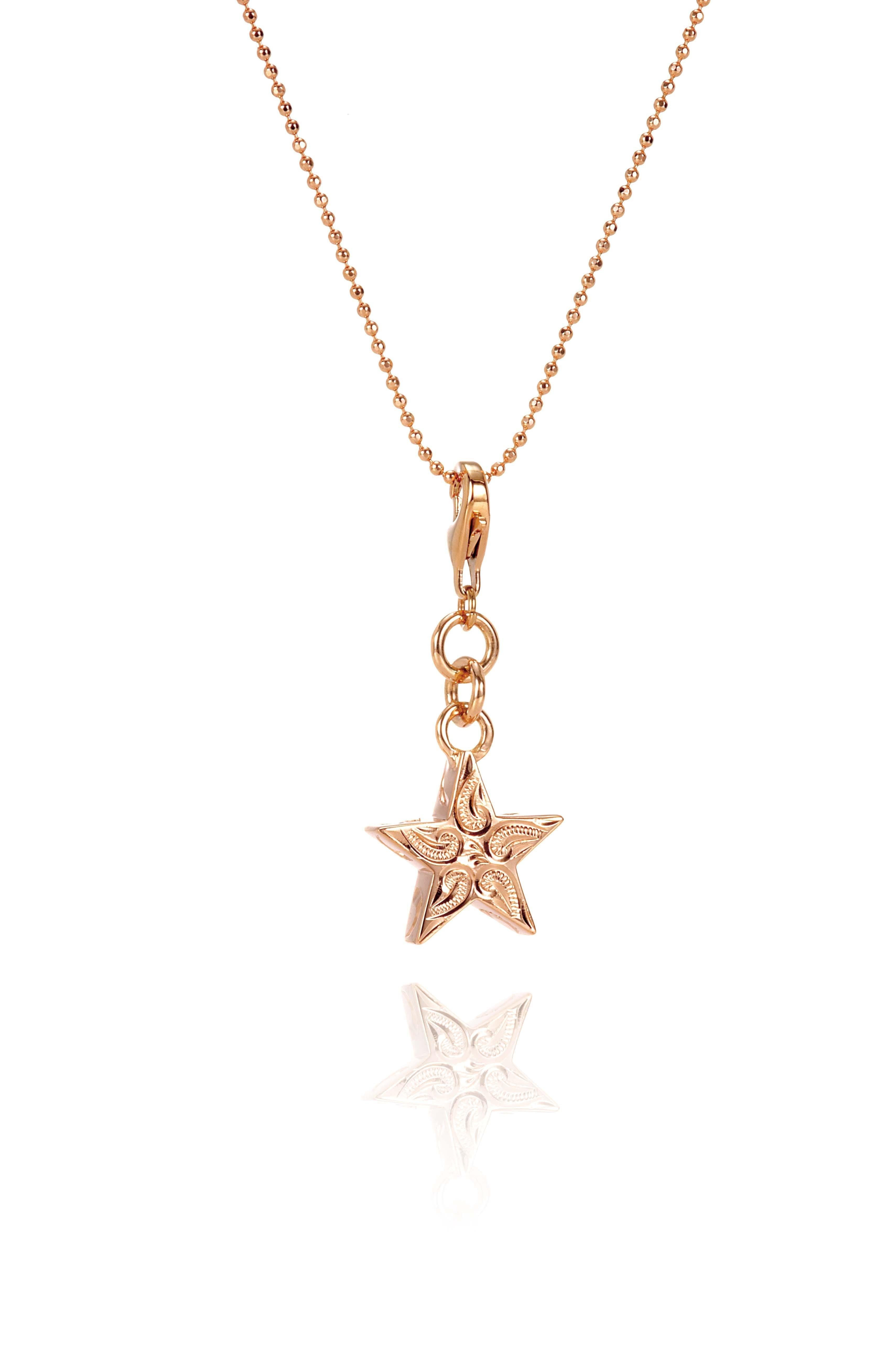 The picture shows a 14K rose gold star charm with paisley hand engravings.