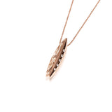 In this photo there is a rose gold surfboard pendant with diamonds and hand engravings.