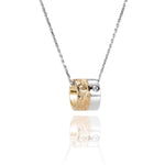 This picture shows a 14k yellow and white gold two-tone barrel pendant with hand engravings and a diamond.