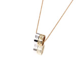 This picture shows a 14k yellow and white gold two-tone barrel pendant with hand engravings and a diamond.