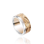 The picture shows a 14K white and yellow gold two-tone 8 mm channel ring with a diamond and hand-engravings.