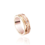 The picture shows a 14K yellow and rose gold two-tone wave channel 6mm ring with a diamond and hand-engravings.