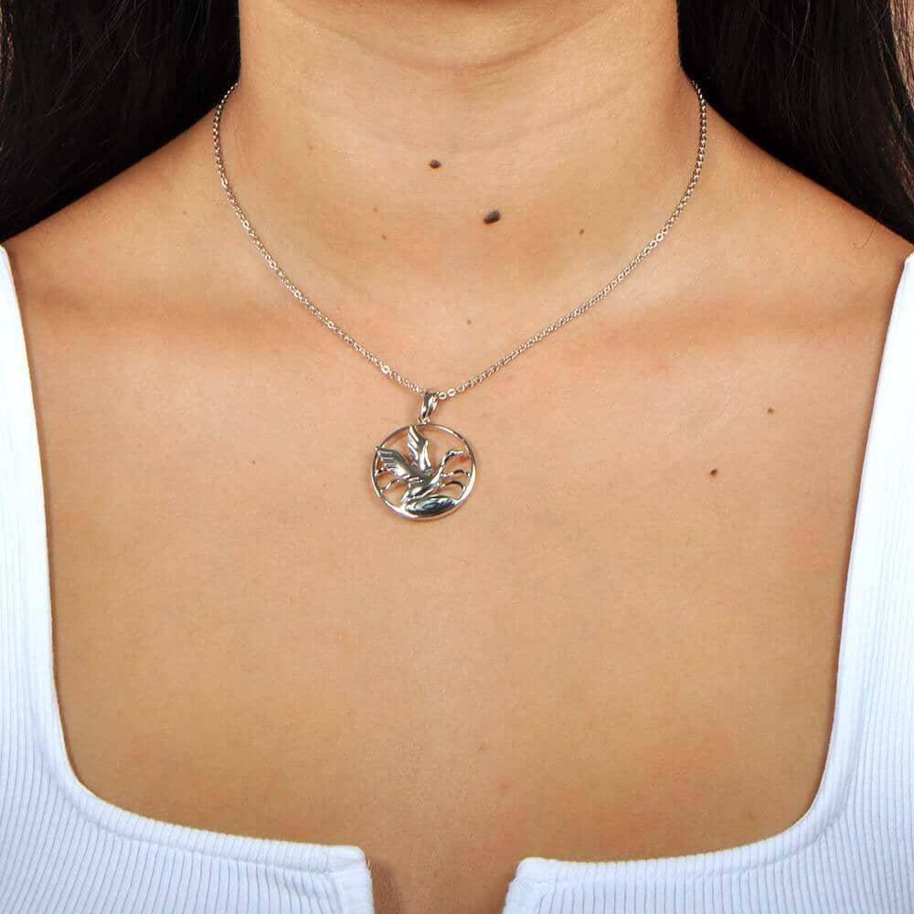 A model wearing the Sterling silver pendant designed to look like a Nene bird flying featuring Abalone.