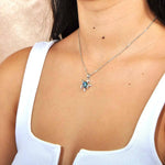 A model wearing a Sterling Silver Sea Turtle pendant, featuring and Abalone Shell.
