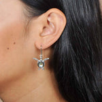 Abalone and sterling silver sea turtle hook earrings worn by a model