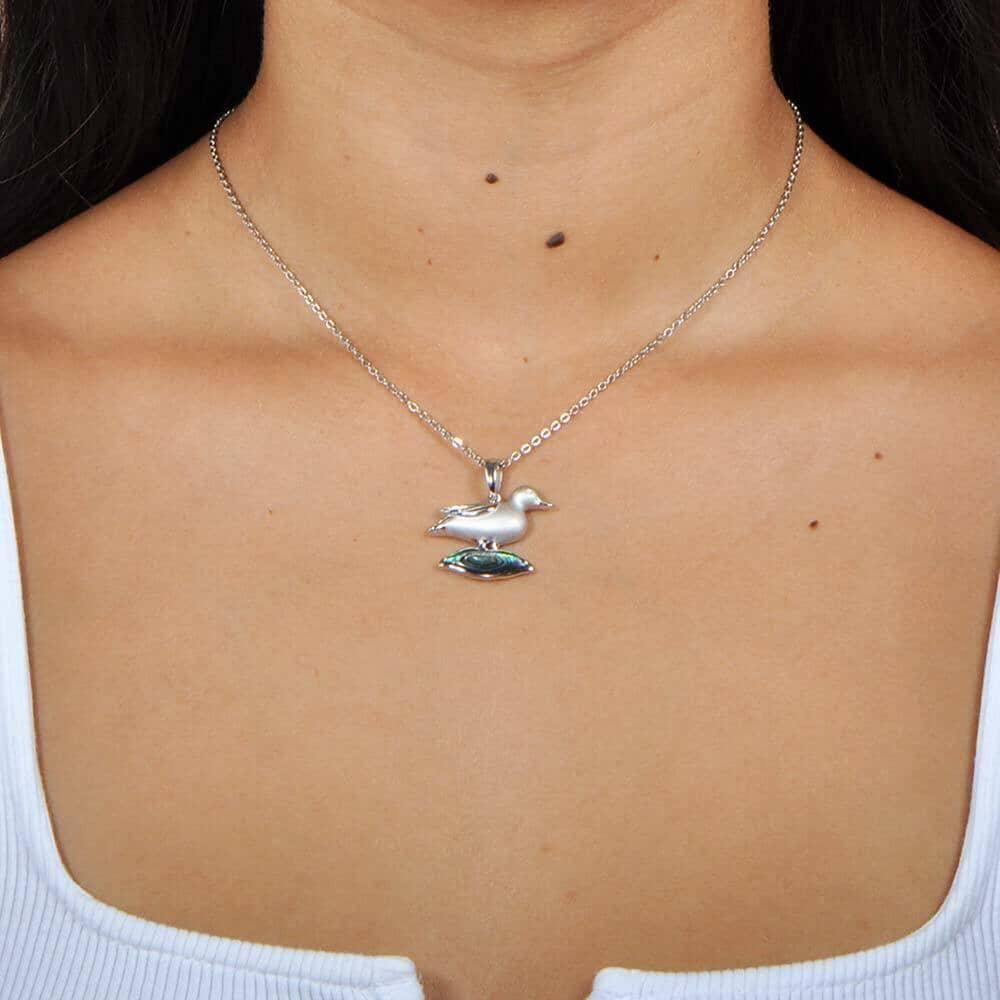 A model wearing a Sterling Silver Nene pendant featuring the bird stood on abalone.
