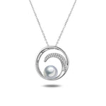 In this photo there is a white gold circle pendant with a wave, diamonds, and one white Akoya pearl.