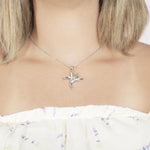 In this photo there is a model with blonde hair and a white shirt with purple flowers, wearing a sterling silver bird of paradise pendant with cubic zirconia.