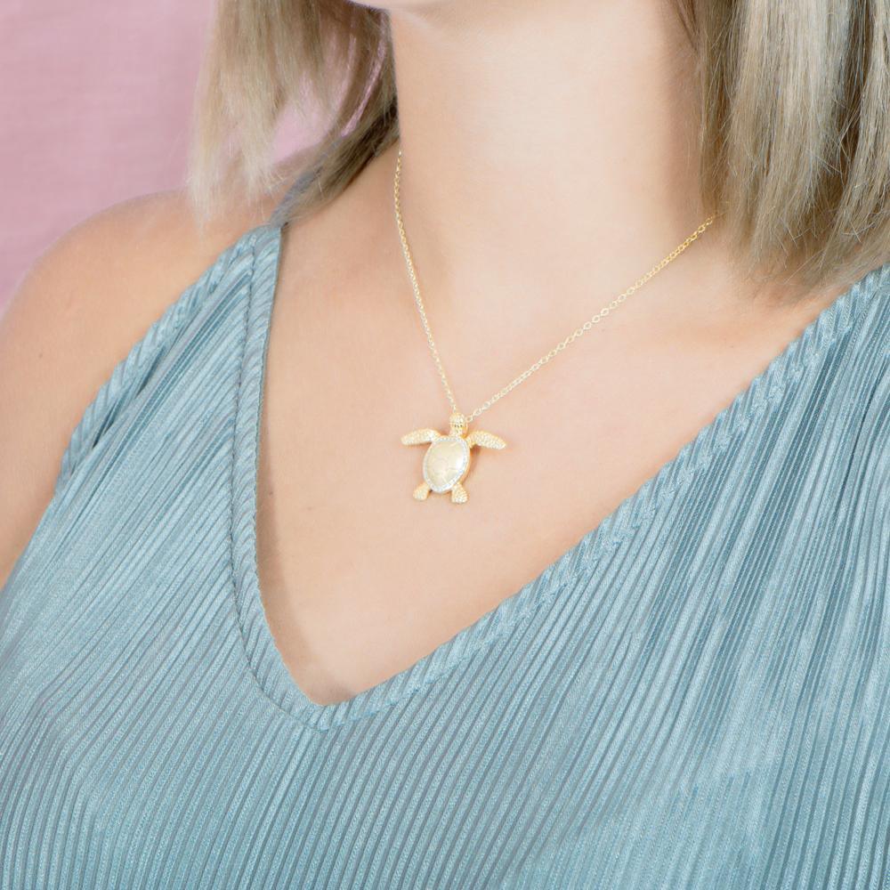The picture shows a 925 sterling silver, yellow gold plated, sea turtle pendant with topaz.