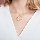 The picture shows a 925 sterling silver, yellow gold plated, two starfish circle pendant with topaz.