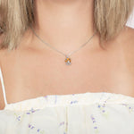Model wearing a pendant made of Koa wood, and sterling silver designed as an octopus