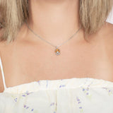 Model wearing a pendant made of Koa wood, and sterling silver designed as an octopus