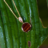 14K gold pendant with a circular Koa wood ornament and diamonds on the bail.