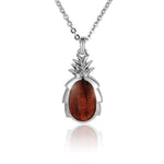 In this photo there is a small sterling silver and koa wood pineapple pendant.
