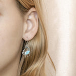 The picture shows a model wearing a 925 sterling silver larimar blue crab earring.