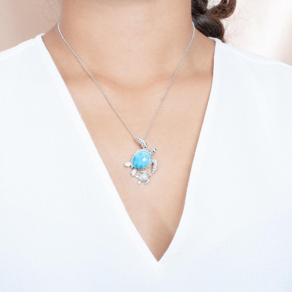 The picture shows a model wearing a 925 sterling silver larimar sea turtle pendant.