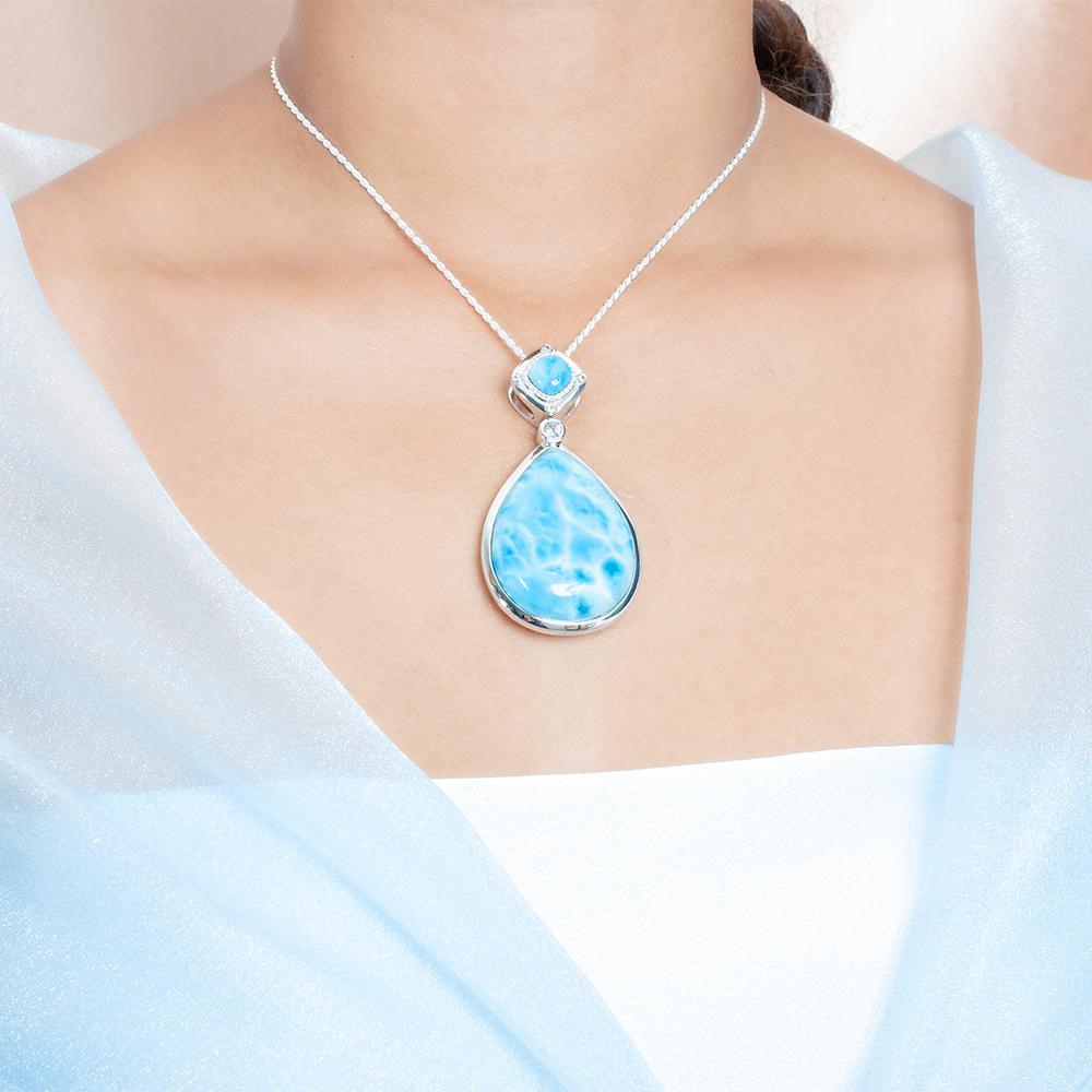 The picture shows a model wearing a 925 sterling silver larimar teardrop pendant.