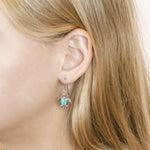 The picture shows a model wearing a 925 sterling silver larimar sea turtle hook earring.