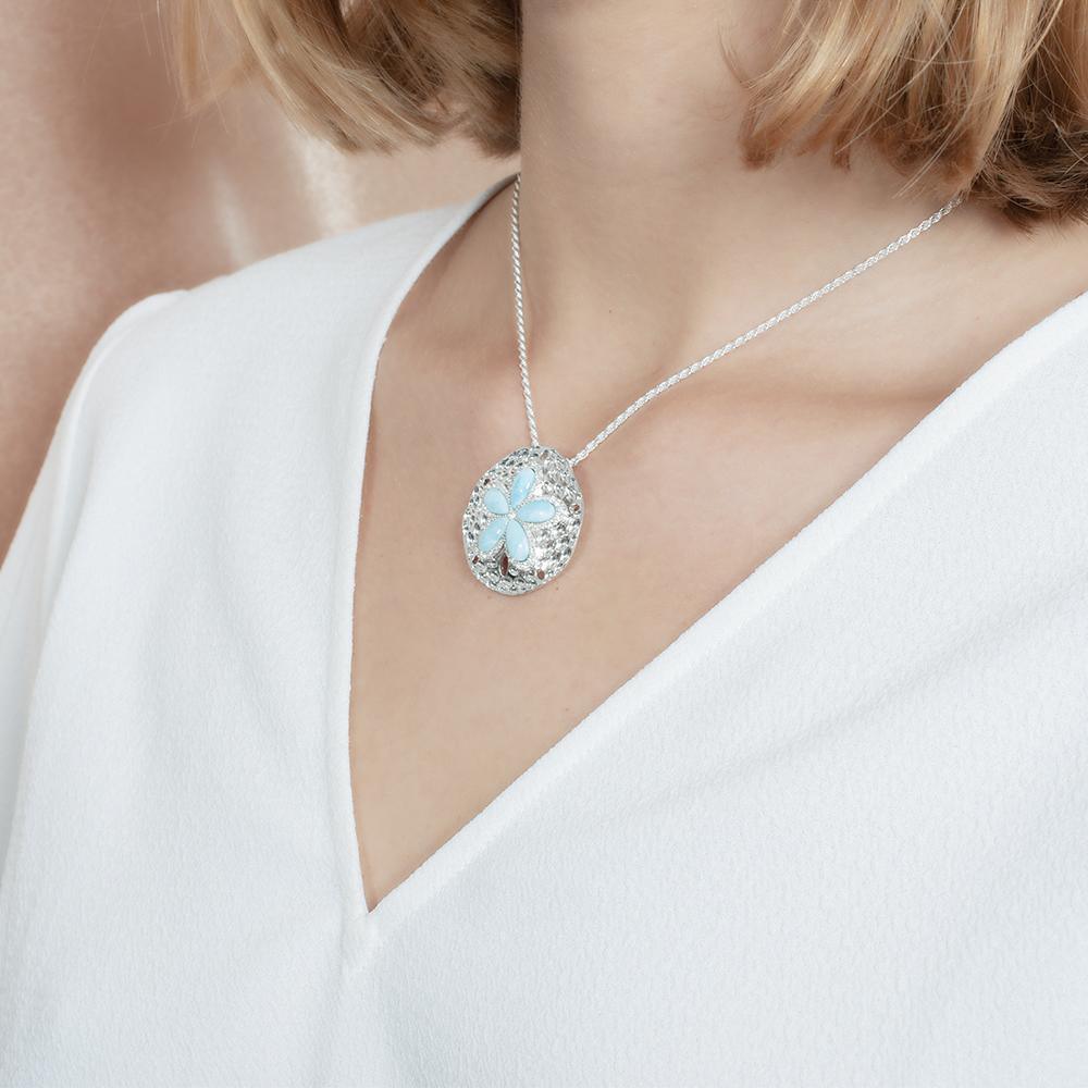 The picture shows a model wearing a 925 sterling silver larimar living sand dollar pendant.