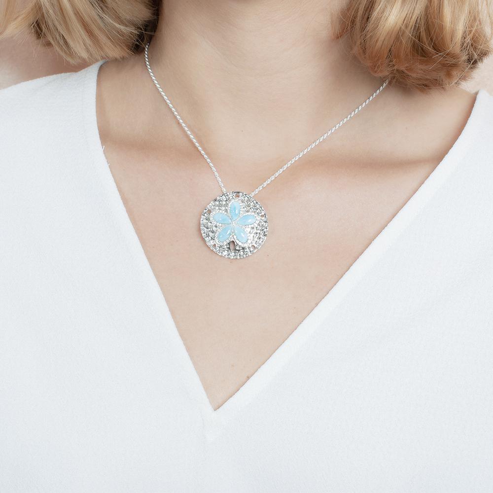 The picture shows a model wearing a 925 sterling silver larimar living sand dollar pendant.