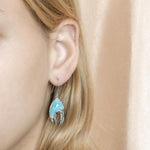 The picture shows a model wearing a 925 sterling silver larimar lobster hook earring.