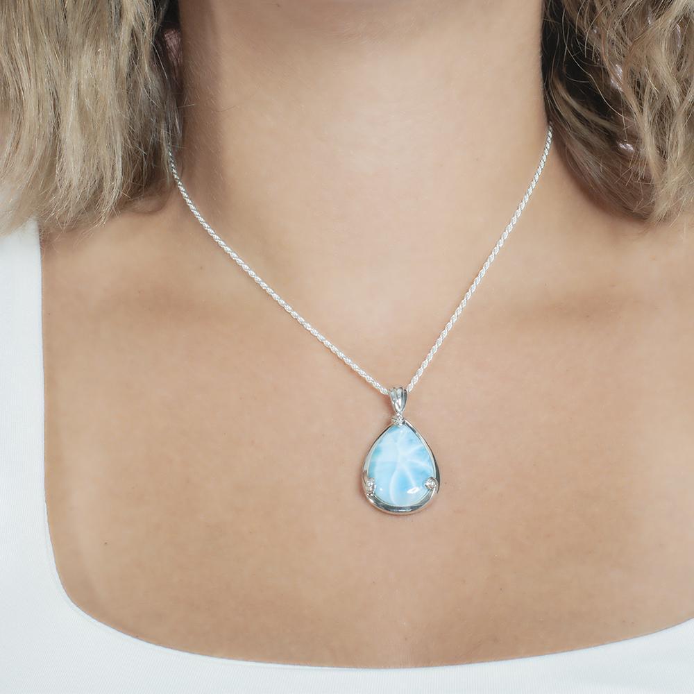 The picture shows a model wearing a 925 sterling silver larimar teardrop pendant.