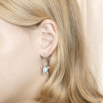 The picture shows a model wearing a 925 sterling silver larimar sea turtle hook earring.
