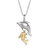 The picture shows a 14K white and yellow gold two dolphin pendant.
