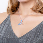 In this photo there is model with blonde hair and a gray shirt wearing a sterling silver dragonfly pendant with blue opalite.