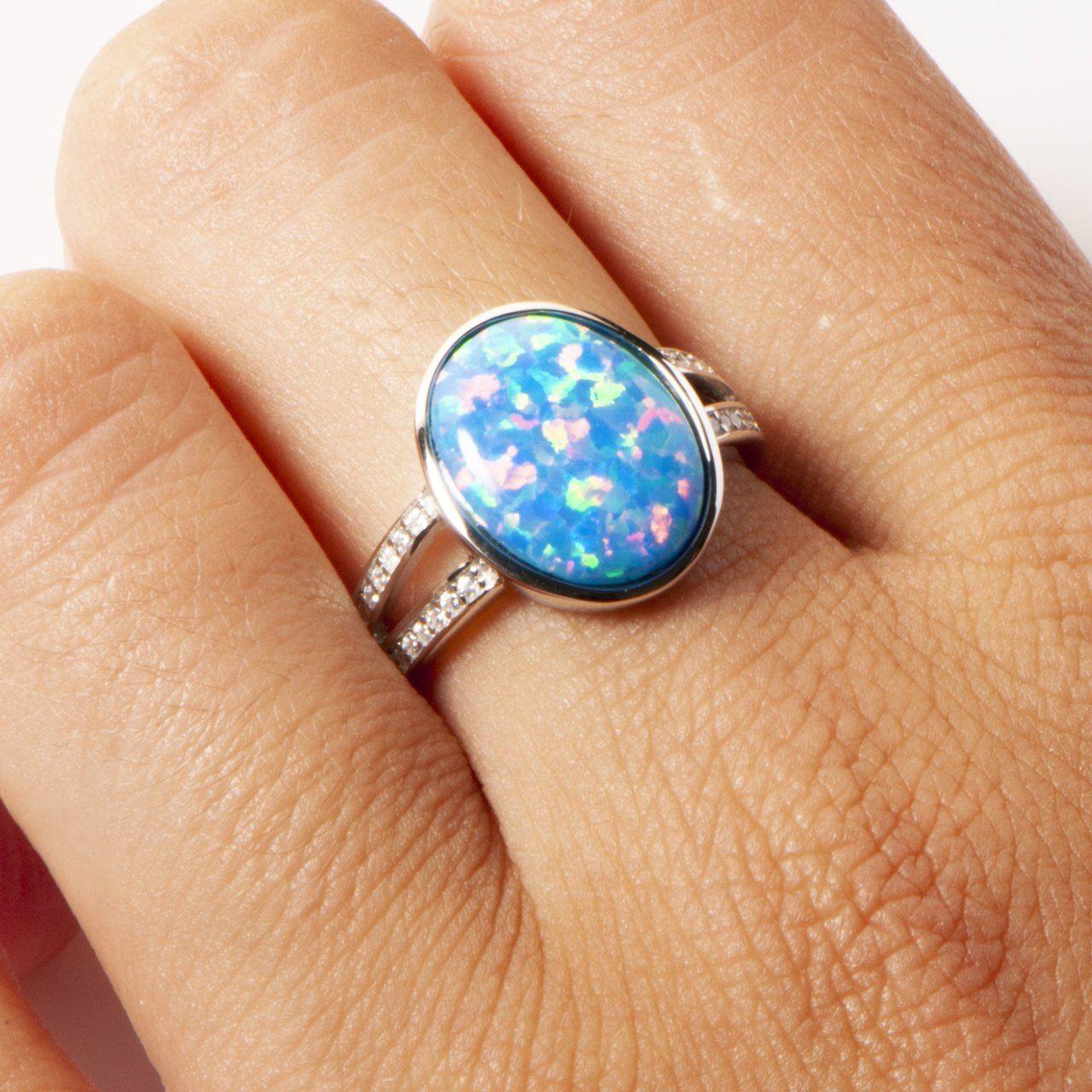 This image shows a model wearing a 925 sterling silver split band ring paired with an oval blue opalite gemstone and topaz