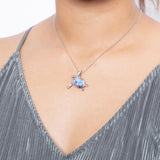 The picture shows a model wearing a 925 sterling silver opalite sea turtle pendant.