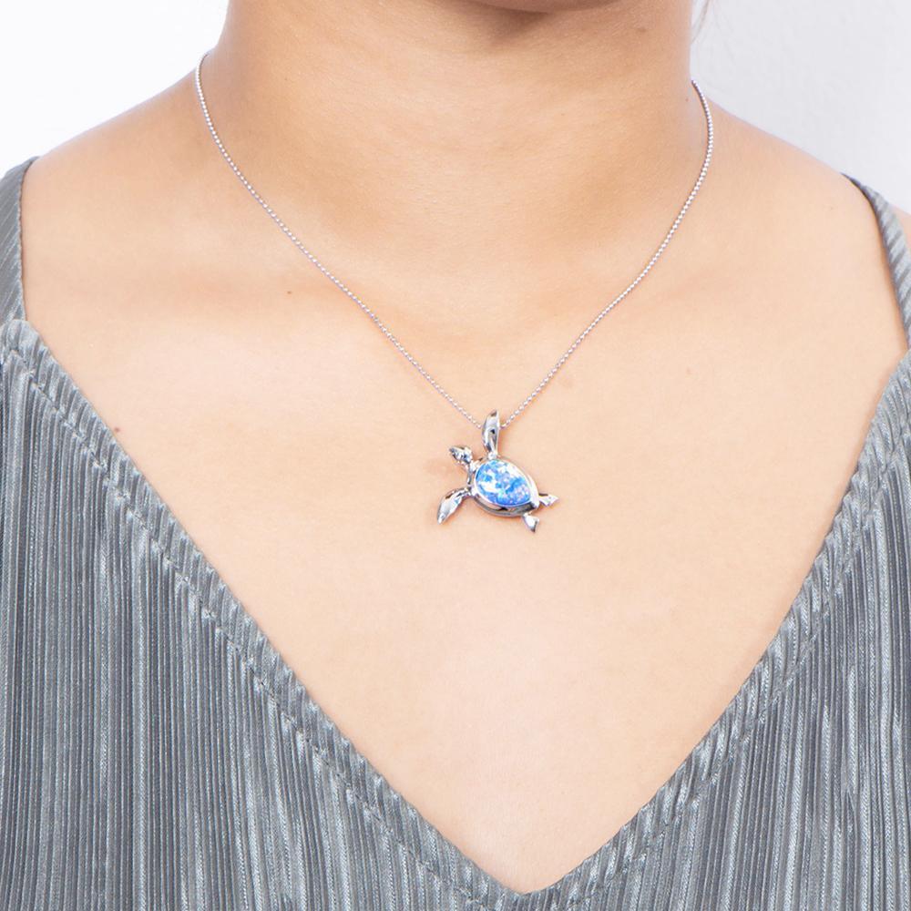 The picture shows a model wearing a 925 sterling silver opalite sea turtle pendant.