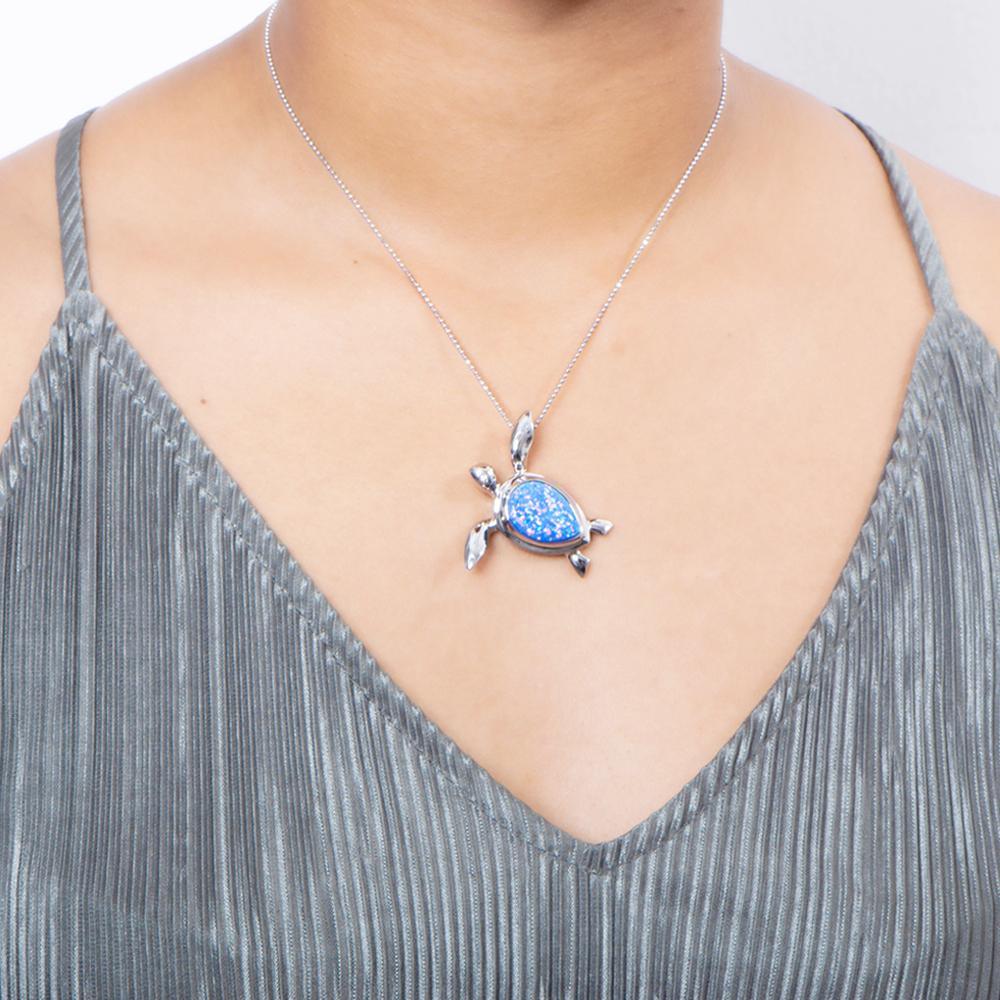 The picture shows a model wearing a 925 sterling silver opalite sea turtle pendant.