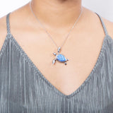 The picture shows a model wearing a 925 sterling silver opalite sea turtle pendant.