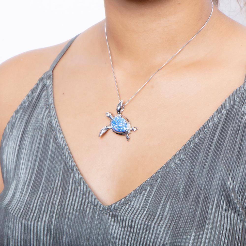 The picture shows a model wearing a 925 sterling silver opalite sea turtle pendant.