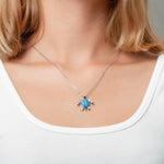 The picture shows a model wearing a 925 sterling silver opalite sea turtle pendant.