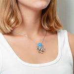 The picture shows a model wearing a 925 sterling silver opalite octopus pendant with topaz.