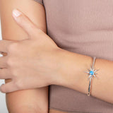 The picture shows a model wearing a 925 sterling silver opalite urchin star bangle.