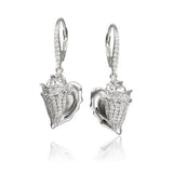 In this photo there is a pair of sterling silver king conch shell earrings with topaz gemstones.