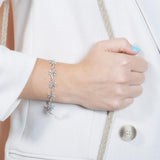 In this photo there is a model wearing a white gold plated palm tree bracelet with topaz gemstones.