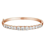 The photo shows a rose gold tennis bracelet bangle with topaz.