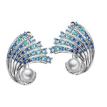 In this photo there is a pair of white gold ombre wave earrings with gradient blue aquamarine gemstones and two white akoya pearls