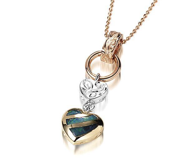 This picture shows a 14K yellow and white gold charm pendant featuring a heart motif paired with opal.