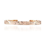 The picture shows a 14K gold bangle with a flower engraving.