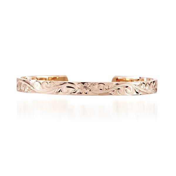 The picture shows a 14K gold bangle with a flower engraving.