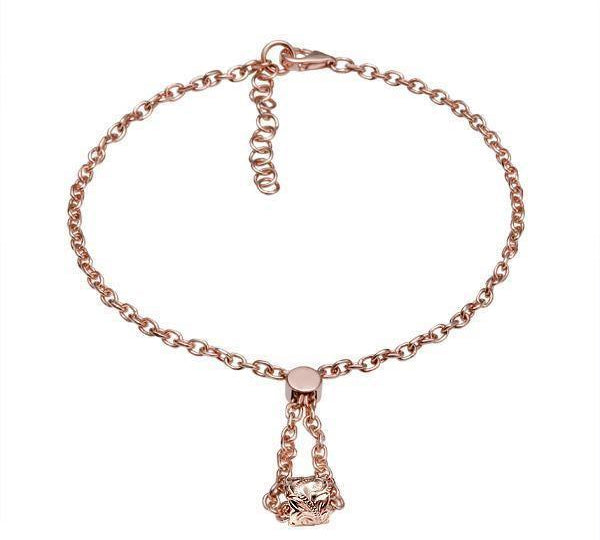 The picture shows a 14K rose gold barrel bracelet with scroll engraving.