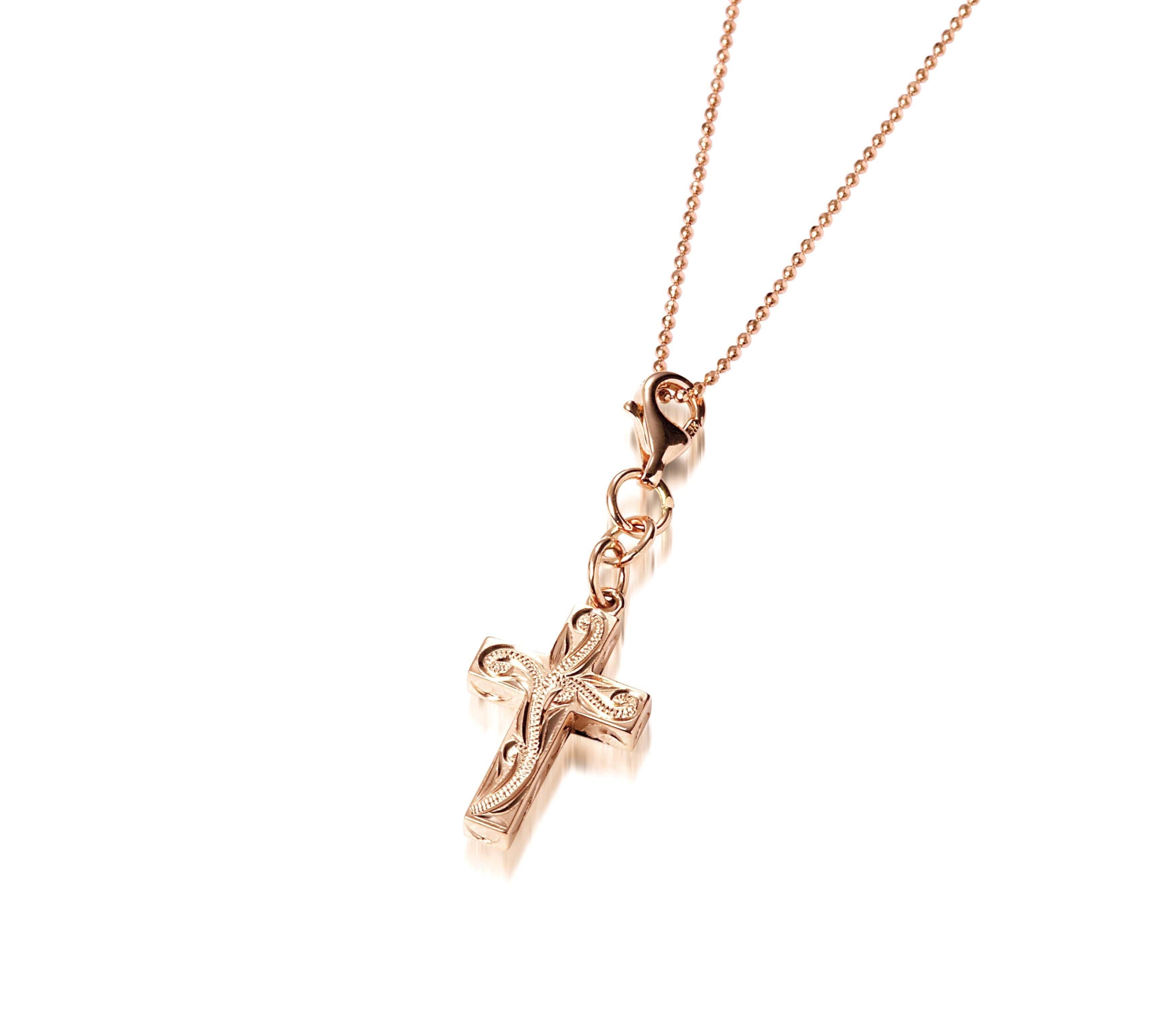 This image is of a 14K yellow gold cross charm with hand-engraved detailing.