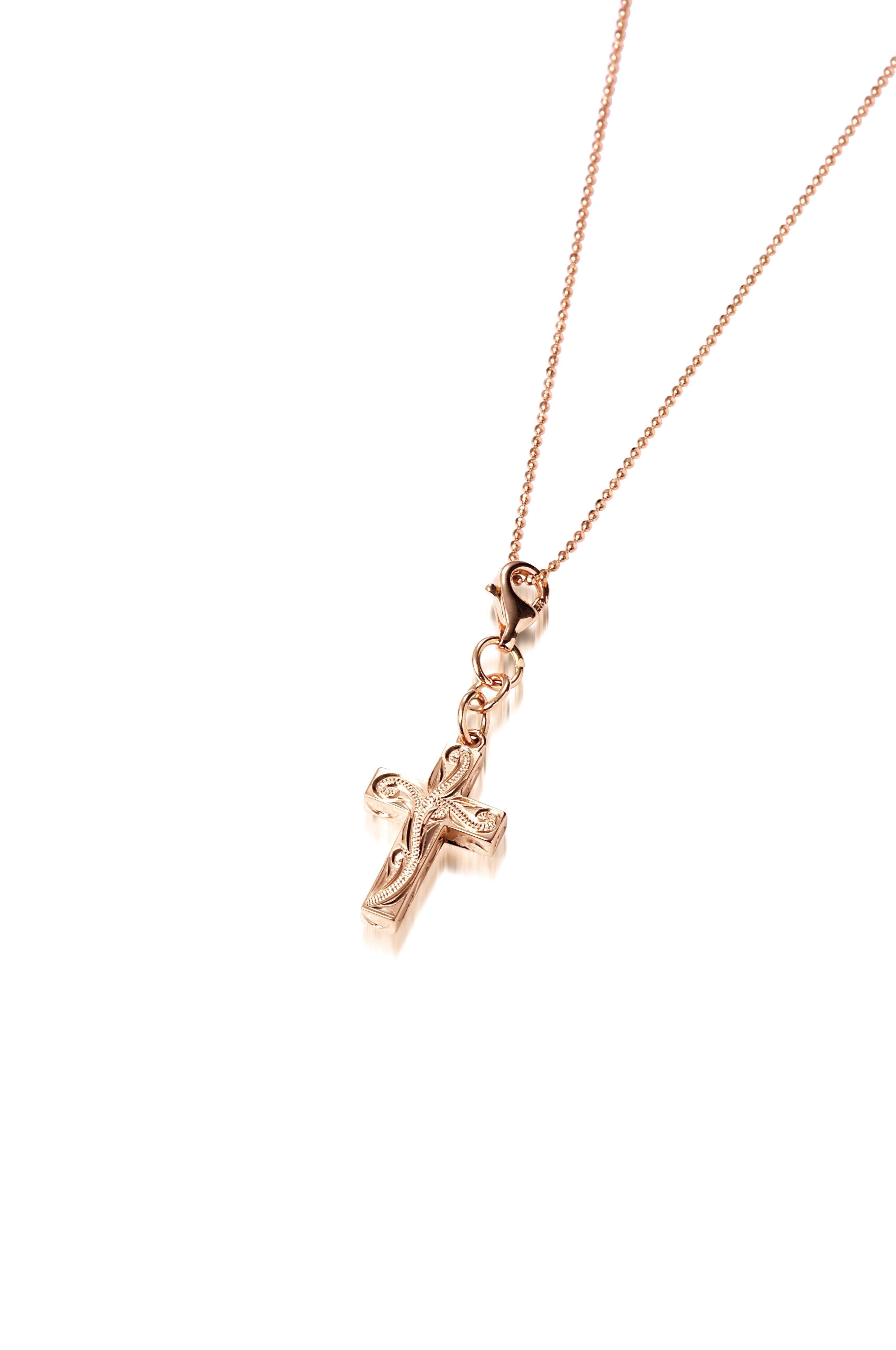 This image is of a 14K yellow gold cross charm with hand-engraved detailing.