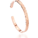 The picture shows a 14K rose gold cut-out bangle with plumeria engraving.